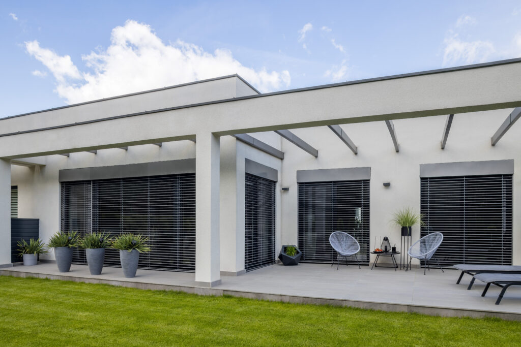 Outside view of elegant suburban house with big window green lawn